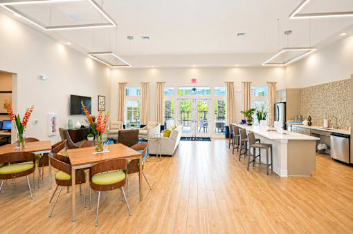 A modern open plan living and kitchen area with wooden floors and furniture.