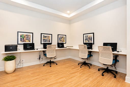 A room with a long desk and four chairs.