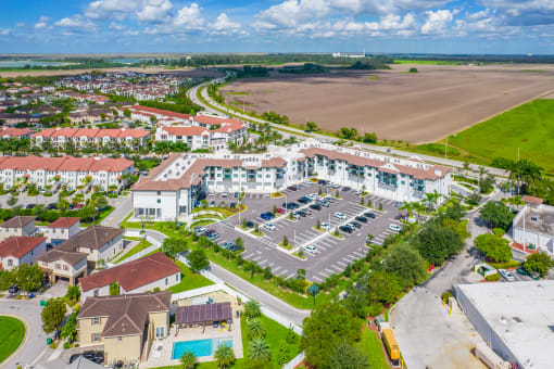 an aerial view of a large apartment complex with a field in the background