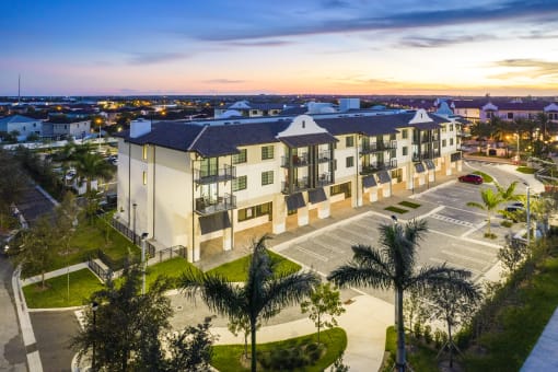 an aerial view of a large apartment complex with a sunset in the background