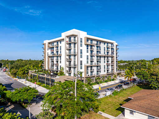 A large white apartment building with balconies and multiple floors.