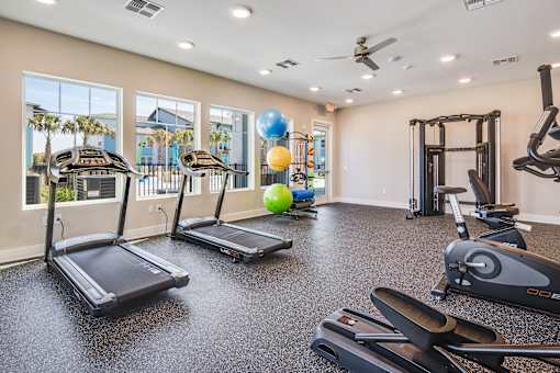 A gym with treadmills, elliptical machines, and a weight machine.