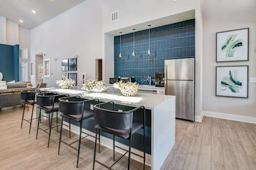A modern kitchen with a bar area and stools.