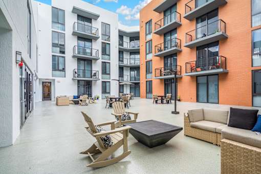 A patio area with furniture and a building in the background.