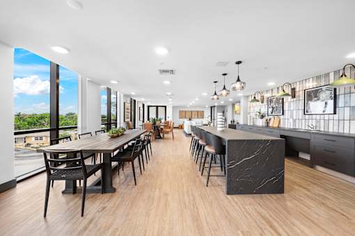 A modern kitchen and dining area with a long table and chairs.