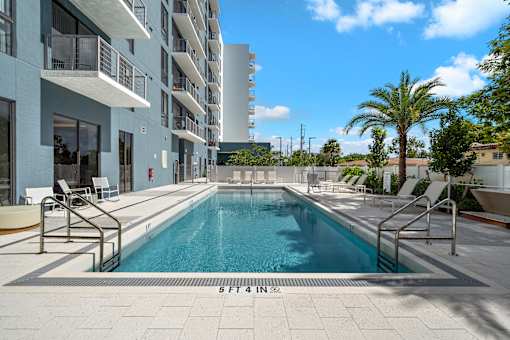 A swimming pool in front of a building with the number 5 on it.
