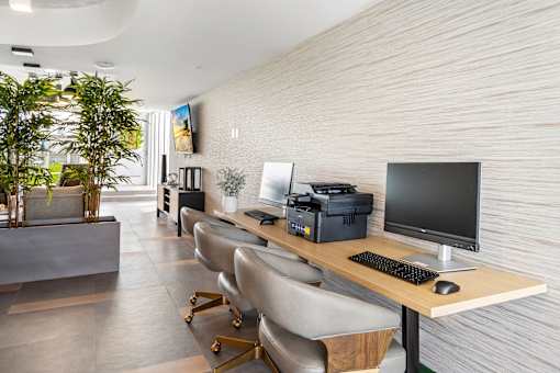 A modern office with a long desk and chairs.