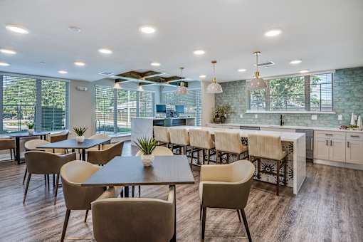A modern dining room with a long table and chairs.