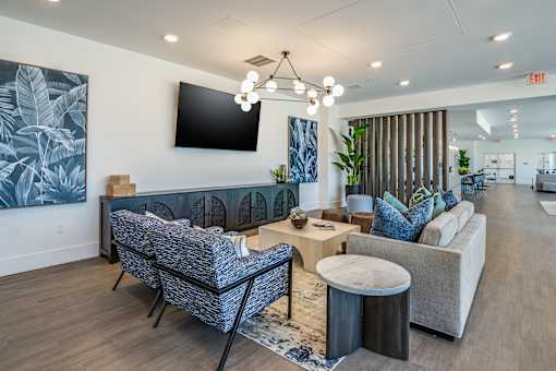 A modern living room with a grey sofa, a blue armchair, and a wooden coffee table.