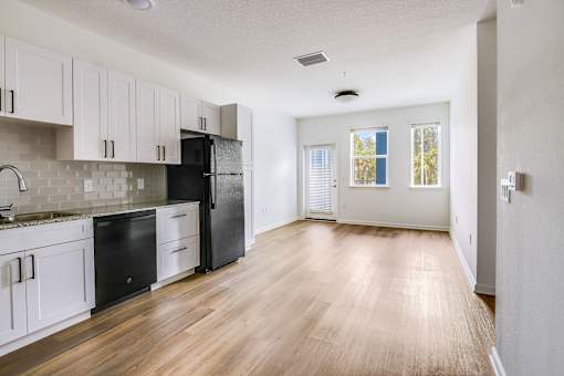 A kitchen with black appliances and white cabinets.