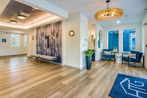 A hallway with a blue rug on the floor and a wooden bench.