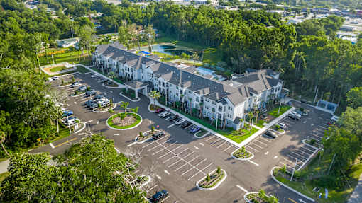 A large white building with a parking lot in front of it.
