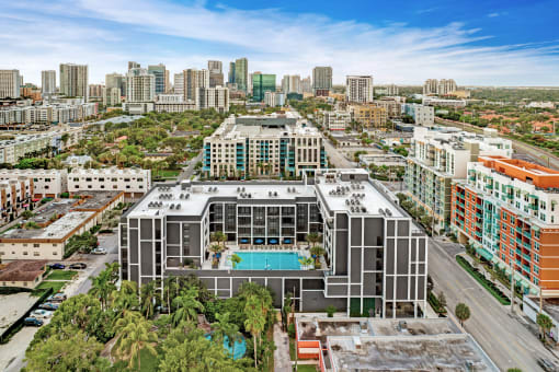 a large building with a pool in front of a city