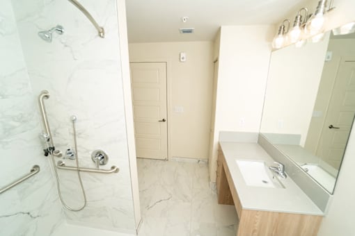 A bathroom with a marble shower and sink.