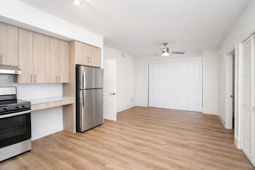 A kitchen with wooden cabinets and a stainless steel refrigerator.