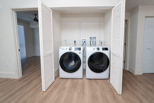 Two washing machines are placed in a laundry room.