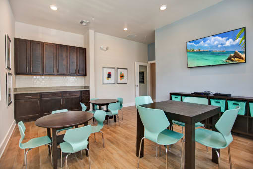 a room with a table and chairs and a flat screen tv on the wall