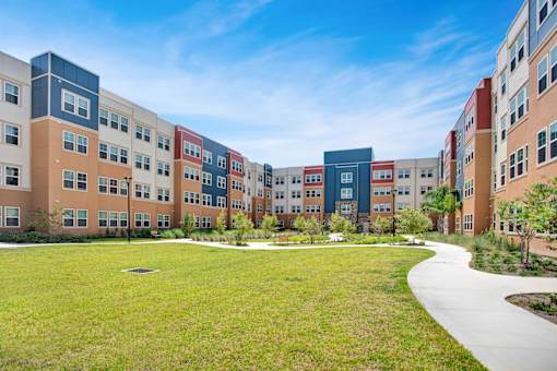 A large grassy area in front of a row of buildings.
