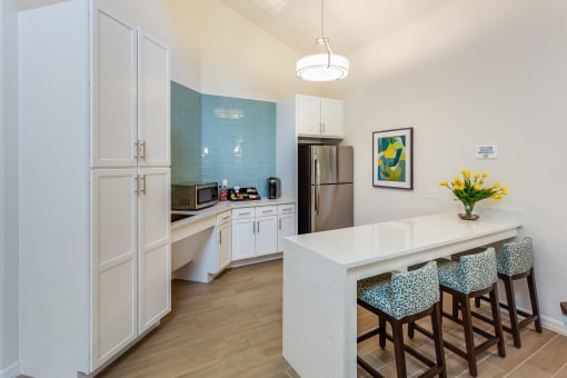 a kitchen with white cabinets and a long white counter