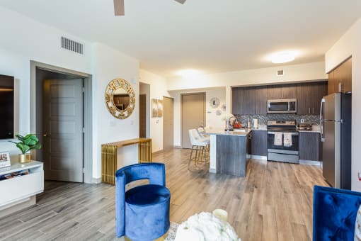 a living room and kitchen area with white walls and hardwood floors