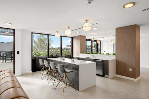 A modern kitchen with a long table and chairs.