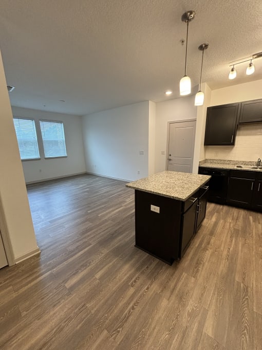 an empty kitchen and living room with a granite counter top