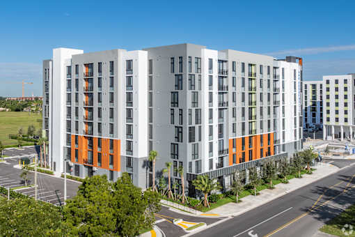 A modern multi-story building with orange and grey accents.