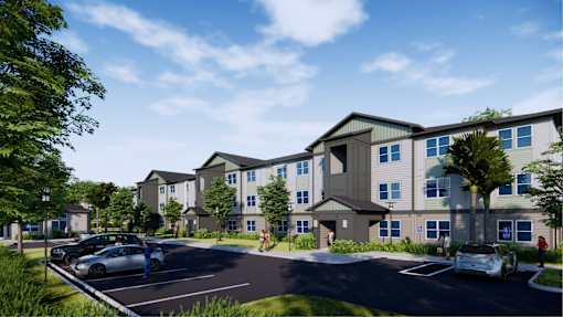 A modern apartment complex with a parking lot in front.