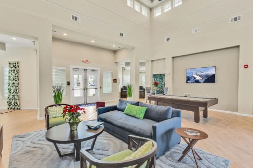 a resident clubhouse with a pool table and couches