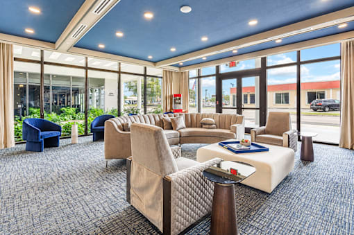A large room with a blue carpet and a long table with chairs on either side.