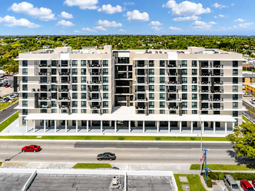A large white building with a parking lot in front of it.