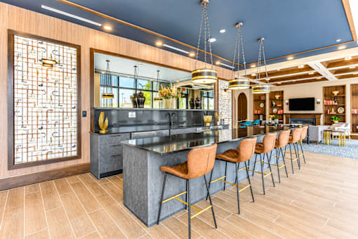 A modern bar with a dark counter and wooden chairs.