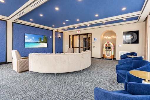 A room with a blue carpet and a white sofa.