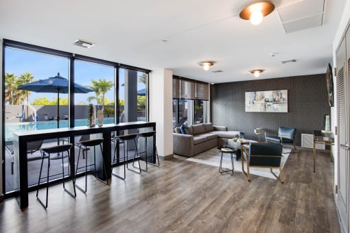 a living room and dining area with a large window and a pool in the background