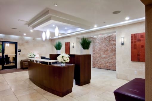 a hotel lobby with a reception desk and a stone wall  at The Sheffield Englewood, New Jersey, 07631