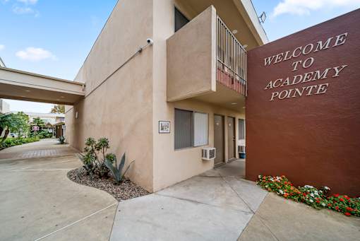 The front of the Academy Pointe building is shown with a welcome sign.