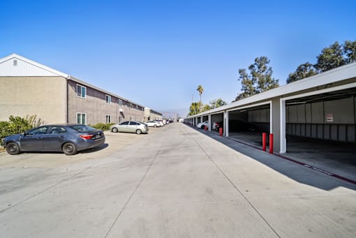 A parking lot with cars and a building in the background.