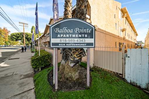A sign for Balboa Pointe Apartments is displayed in front of a building.