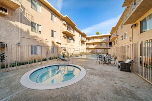 A small pool in a courtyard surrounded by buildings.