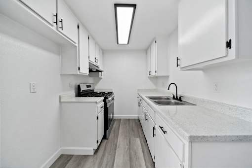 A kitchen with white cabinets and a black stove top oven.