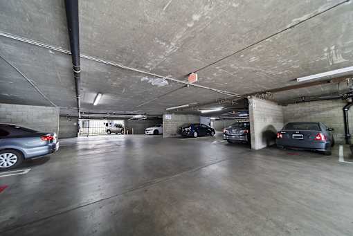 A parking garage with several cars parked in it.