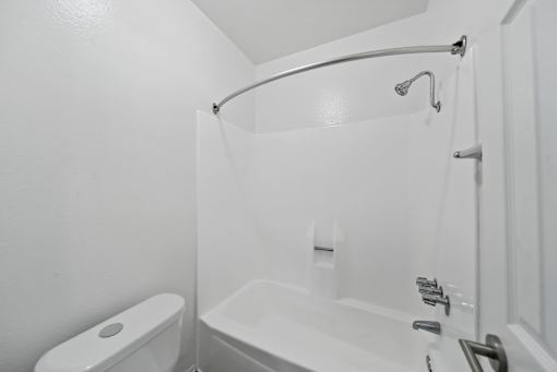 A white bathroom with a toilet, sink, and bathtub.