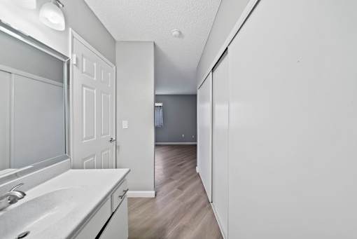 A white kitchen with a sink and a door.