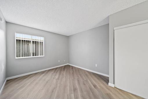 A room with a window and wooden flooring.