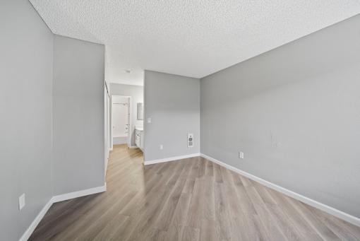 A room with wooden flooring and white walls.