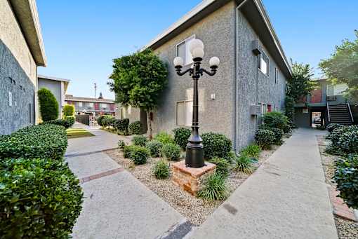 A street lamp stands on a brick base in front of a building.
