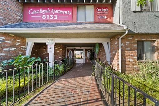 The image shows the entrance to Casa Royale Apartments with a red sign displaying the number 8133.