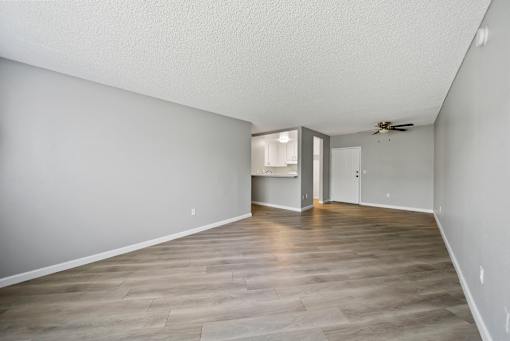 A room with a ceiling fan and a doorway leading to another room.