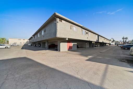 A concrete building with a parking lot in front.