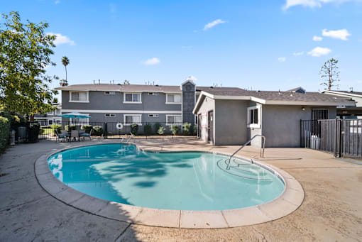 A swimming pool in a backyard with a house in the background.